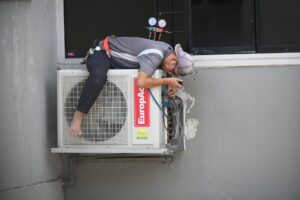 man in gray t shirt fixing the aircon